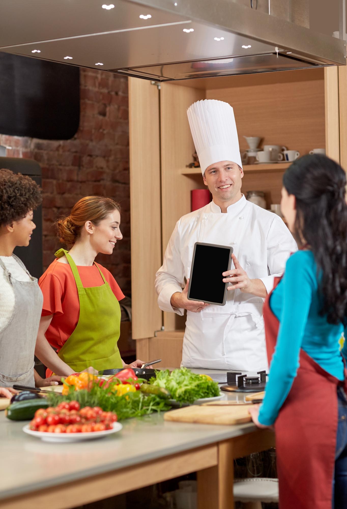 Instructor speaking to students in a studio kitchen