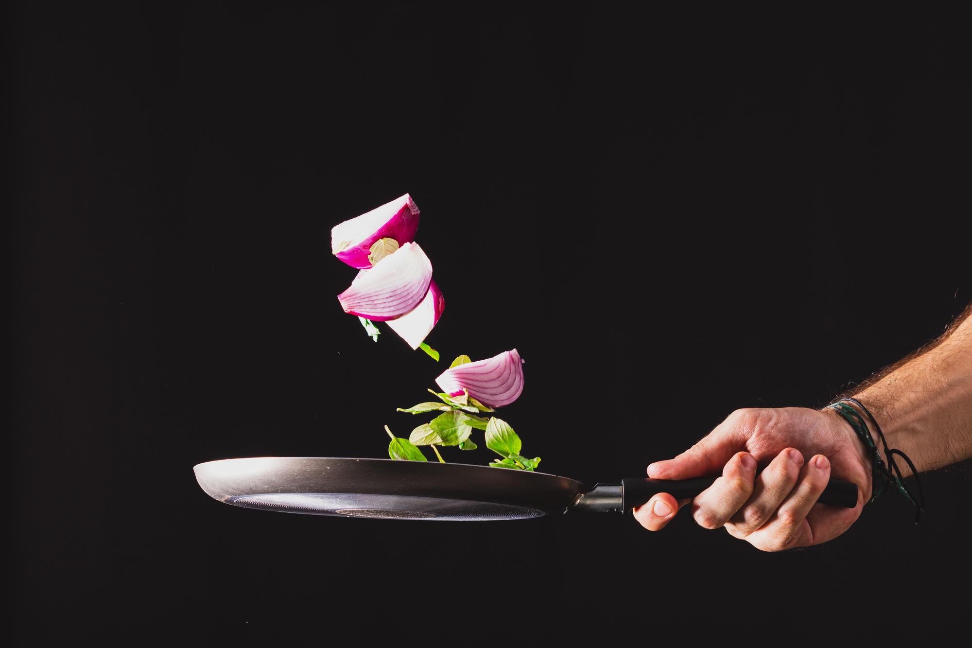 Chef plating a precise dish under studio lights